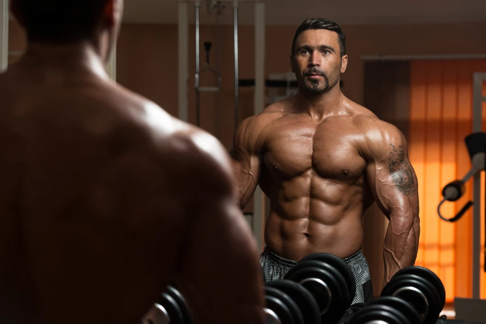 Latin Bodybuilder Working Out Biceps Dumbbell Concentration Curls